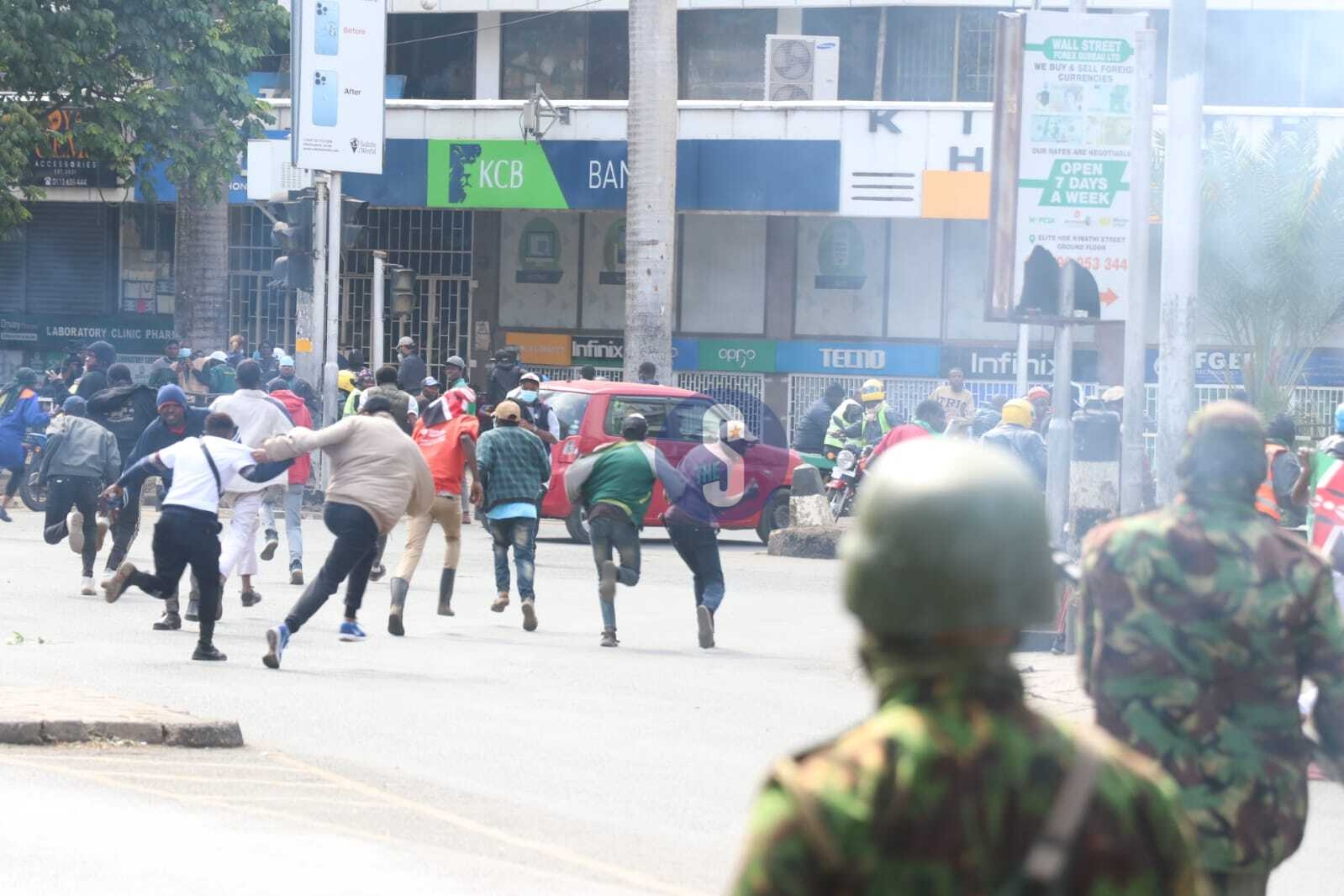 PHOTOS: Protesters run for safety after teargas lobbed